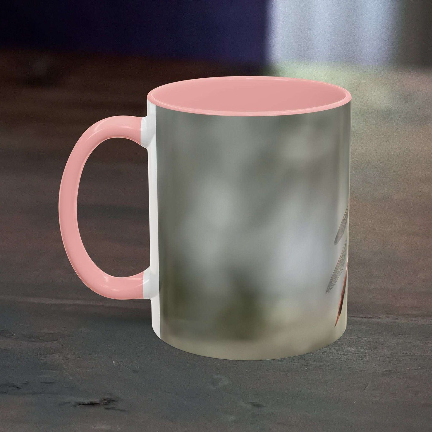 Pretty Dragonfly Accent Coffee Mug with pink handle and interior on a wooden table.