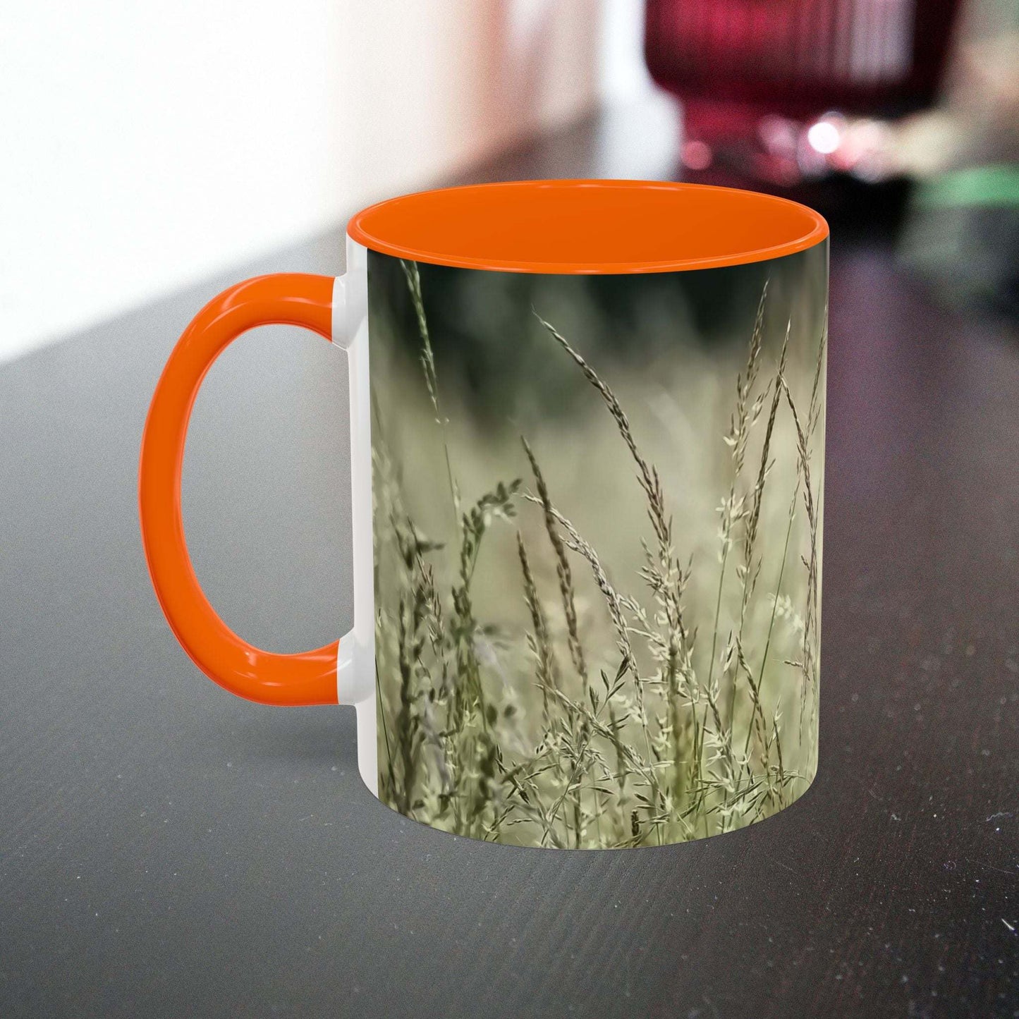 Ceramic mug with flowering grass design, orange handle, nature-inspired gift.