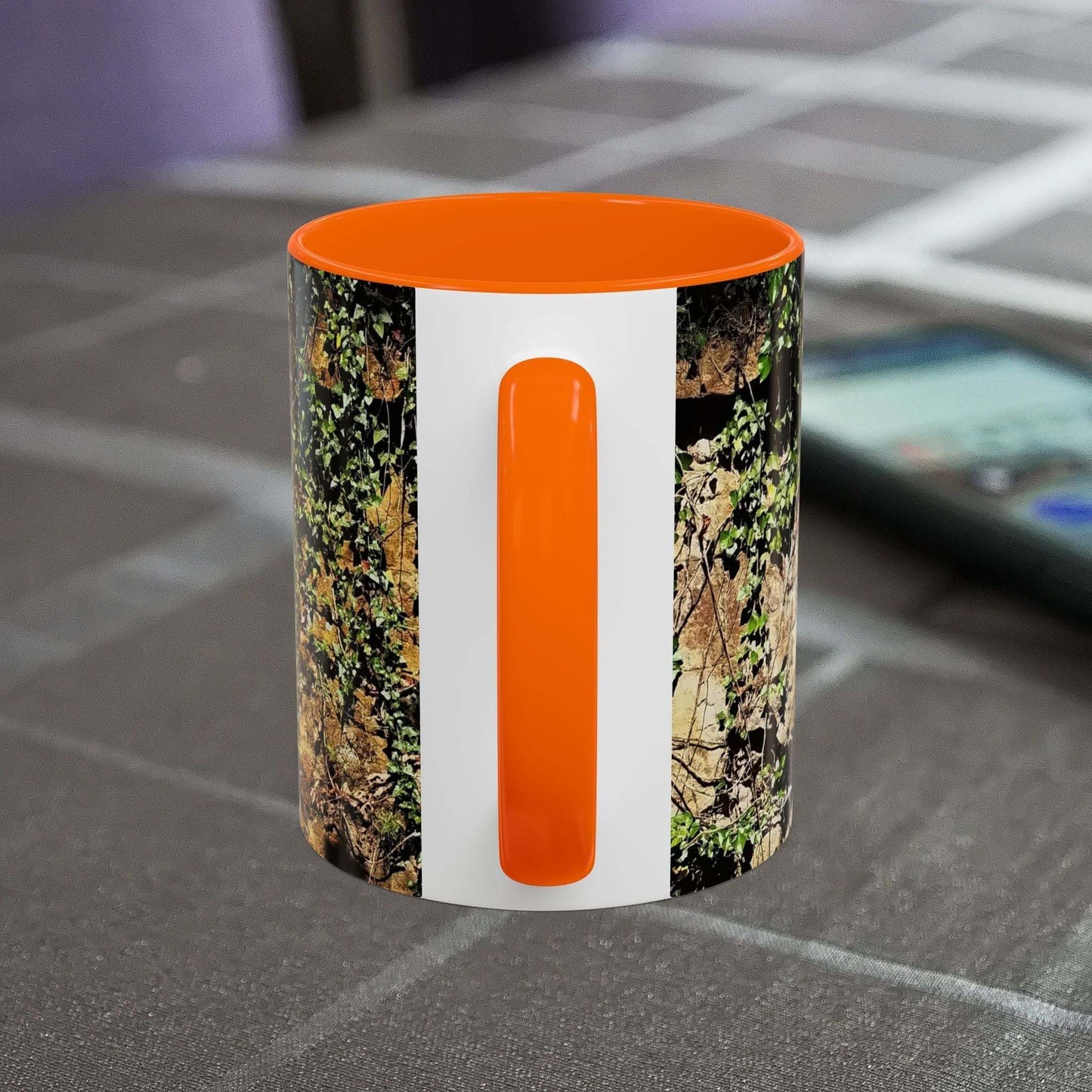 Overgrown rocks adventure coffee mug with nature-inspired design and orange handle.