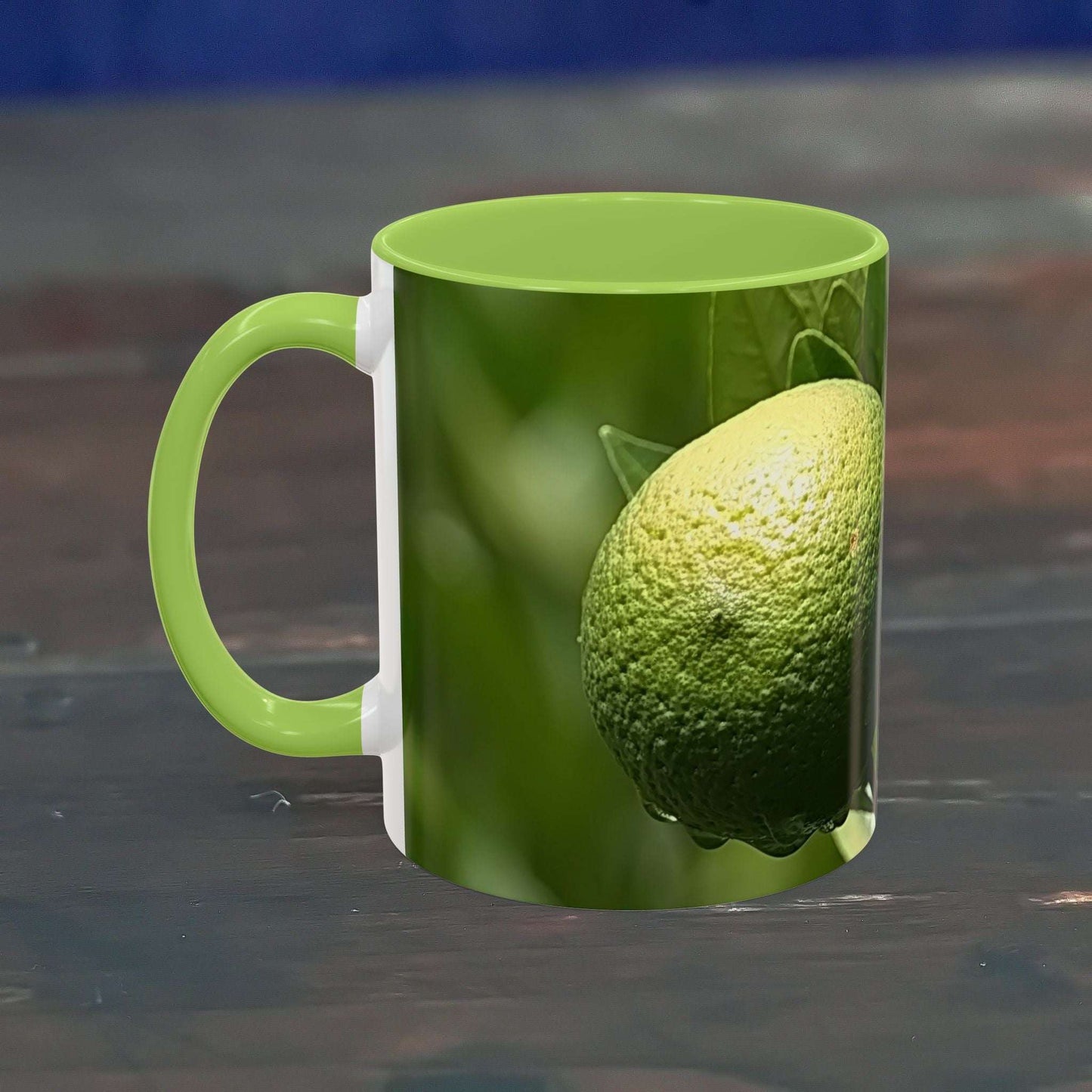 Vibrant fruit coffee mug with lime design, glossy finish, and green interior on a reflective surface.