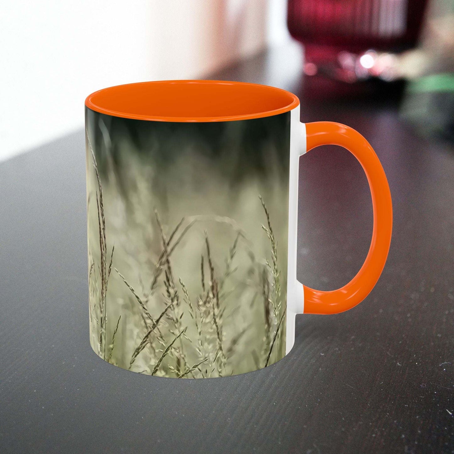 Ceramic mug with flowering grass design and orange handle, perfect for nature lovers.