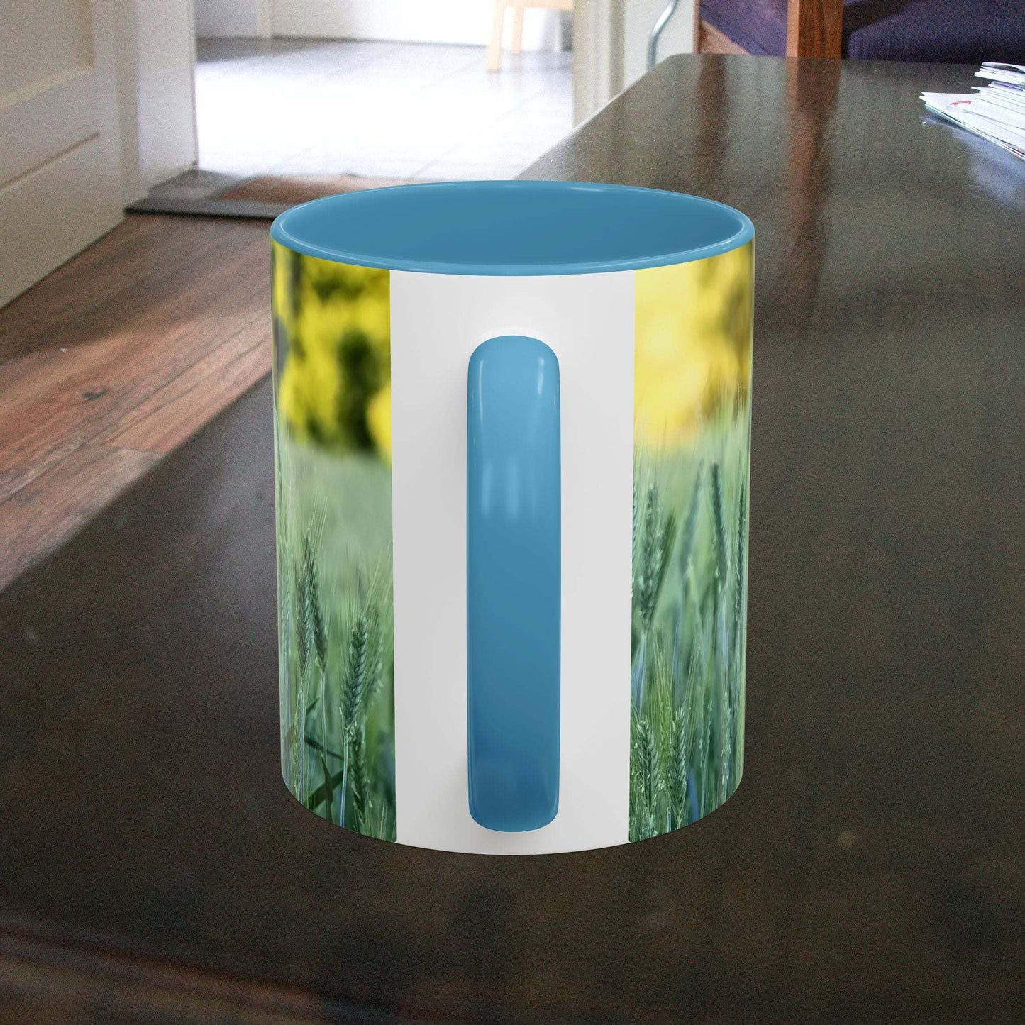 Wheat field design coffee mug on dark wooden table.