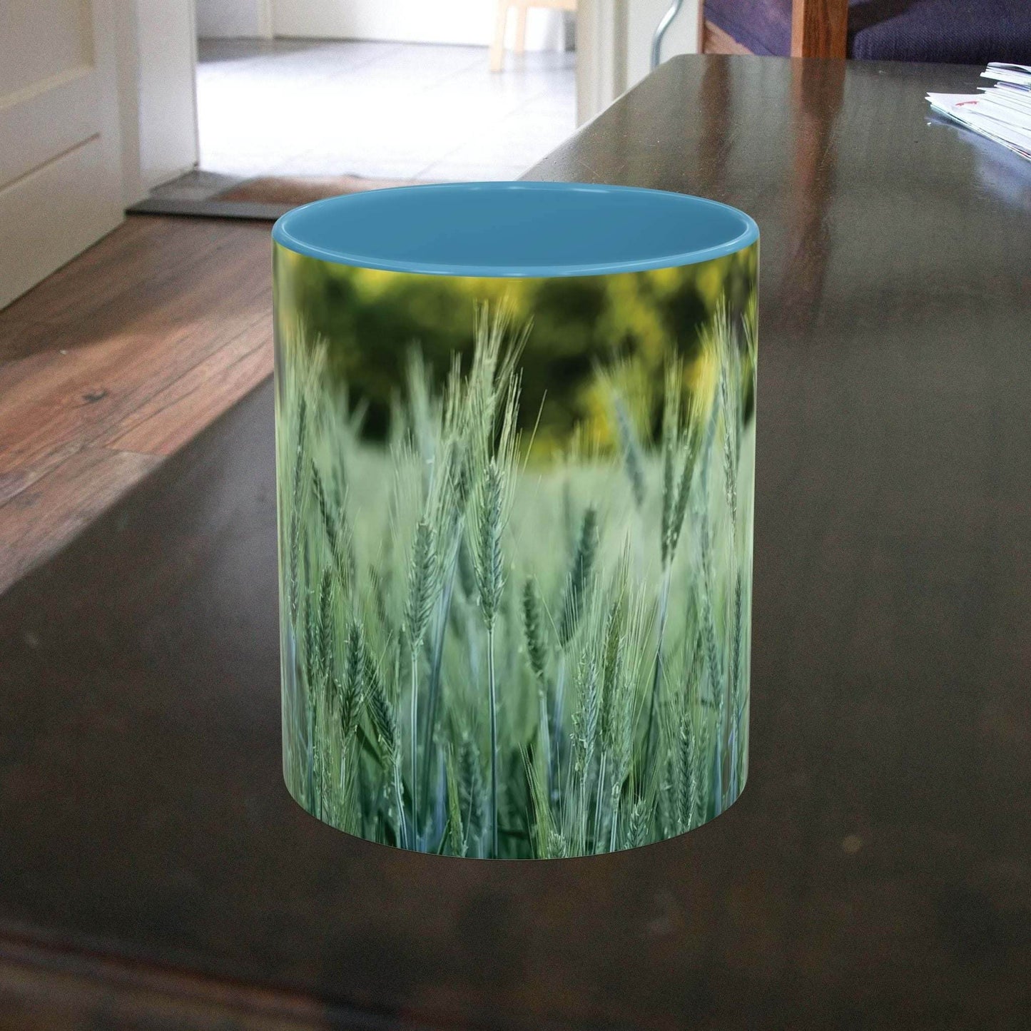Wheat field design coffee mug with nature-inspired pattern on wooden table.