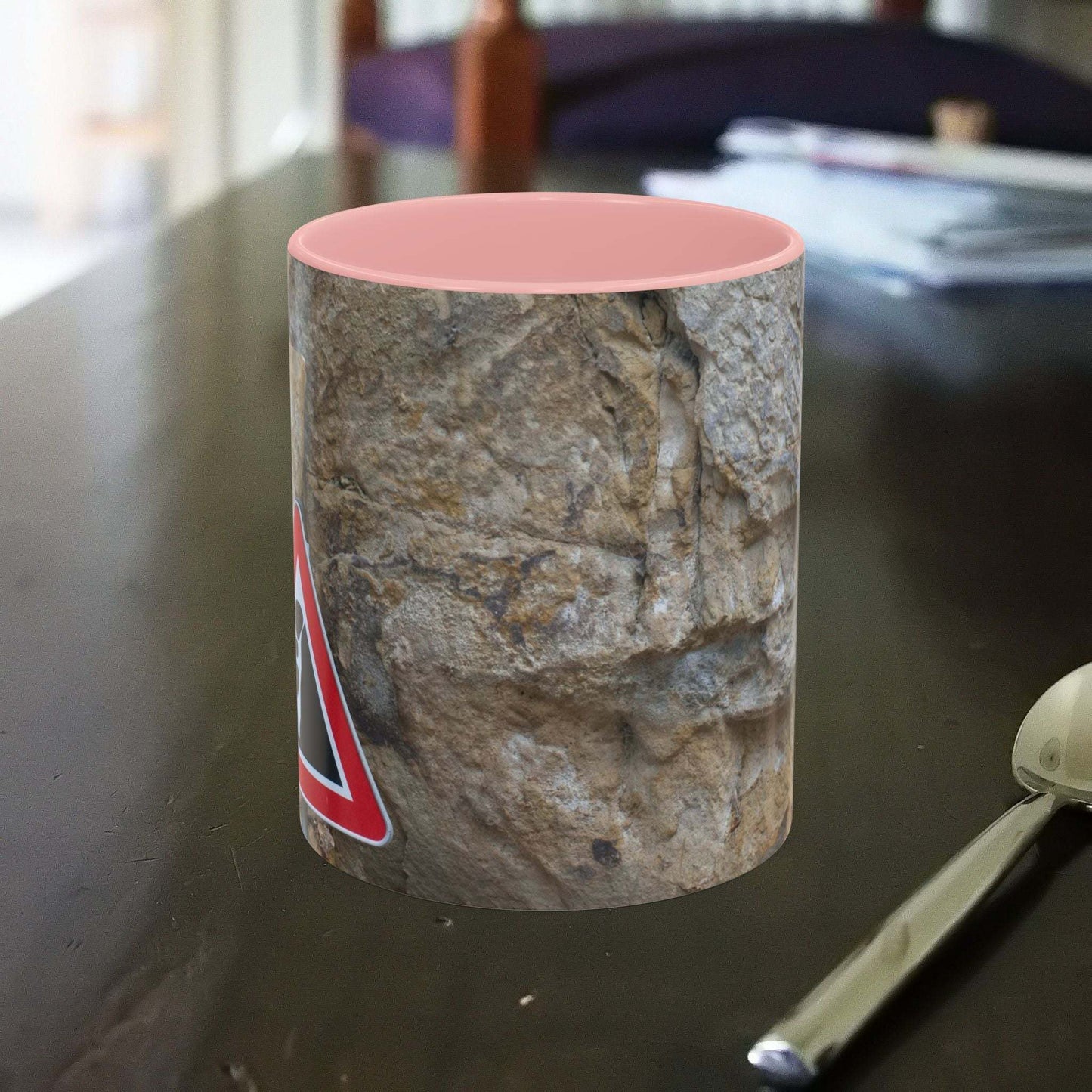Rocky Mug with falling rocks design on table, ideal for mountain lovers and outdoor enthusiasts.