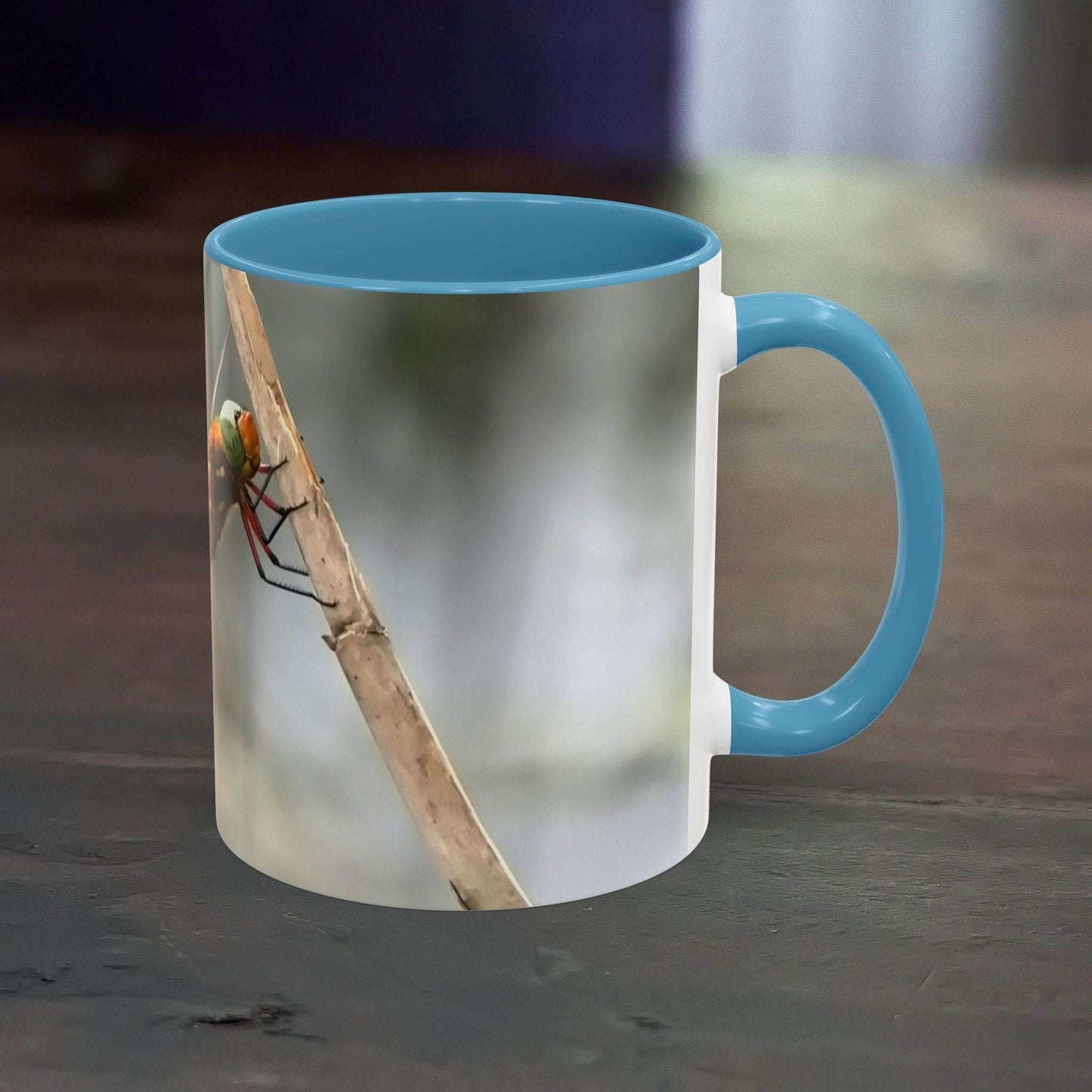 White ceramic mug with a colorful dragonfly design, blue interior, 11oz capacity.