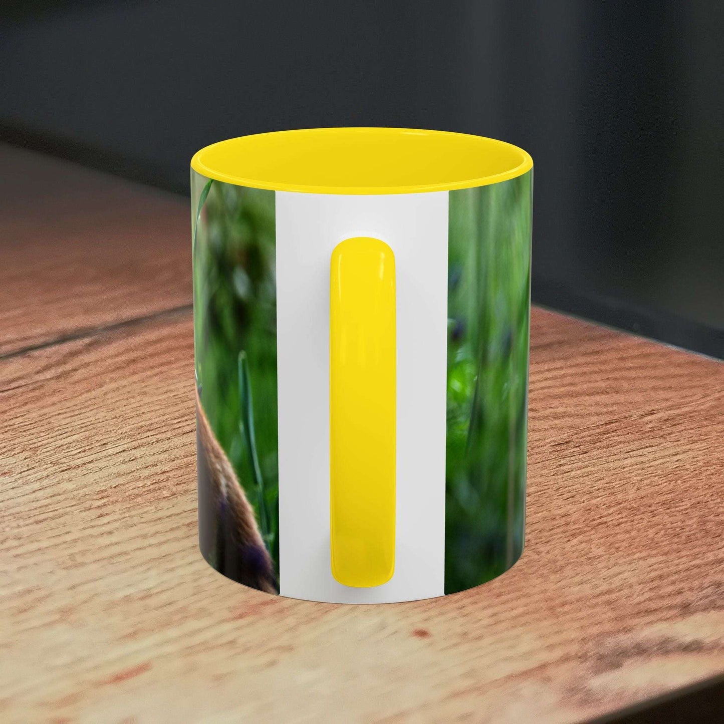 Fox-inspired accent coffee mug with yellow handle on wooden surface.