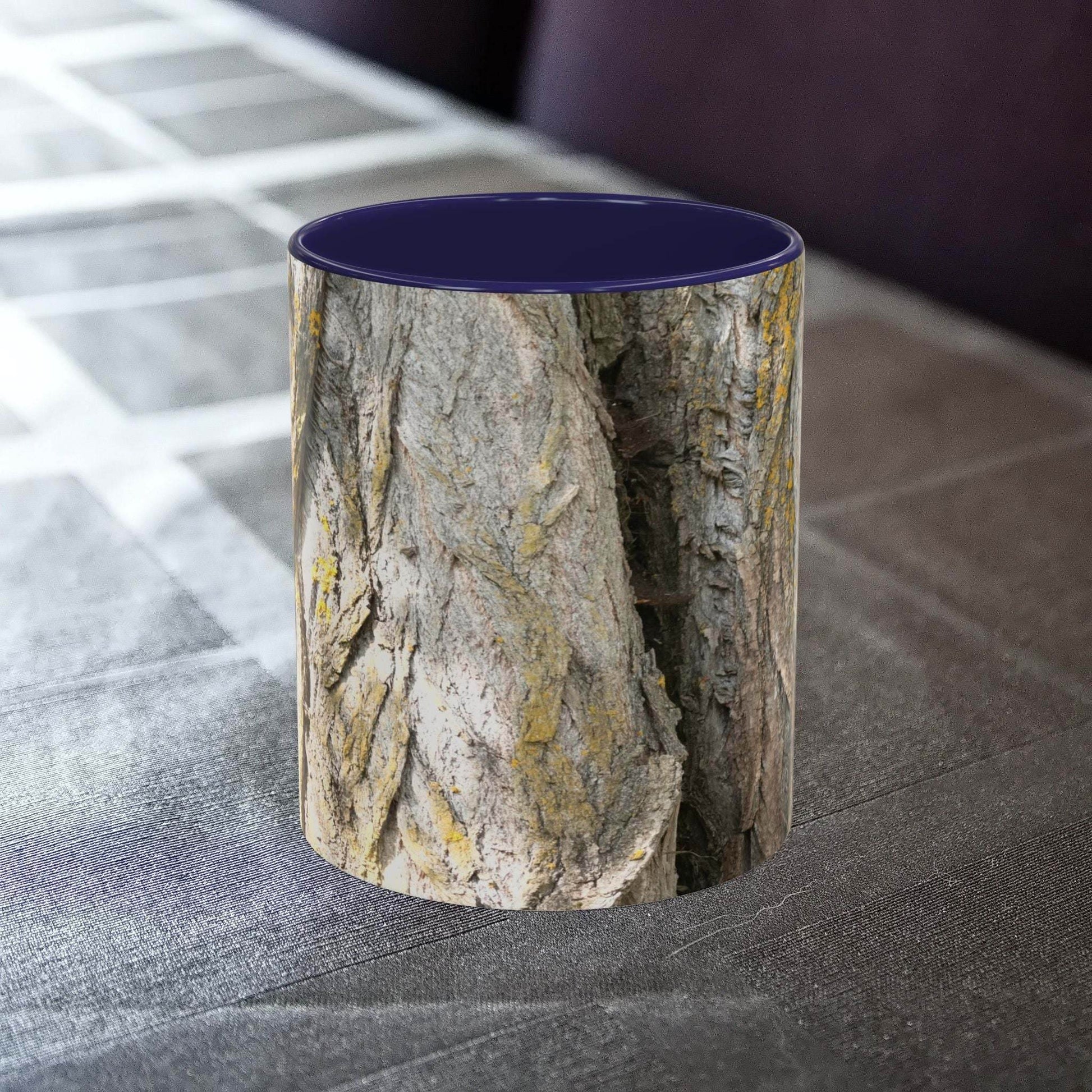 Coffee mug with tree trunk design on a table, offering a rustic, cozy vibe.