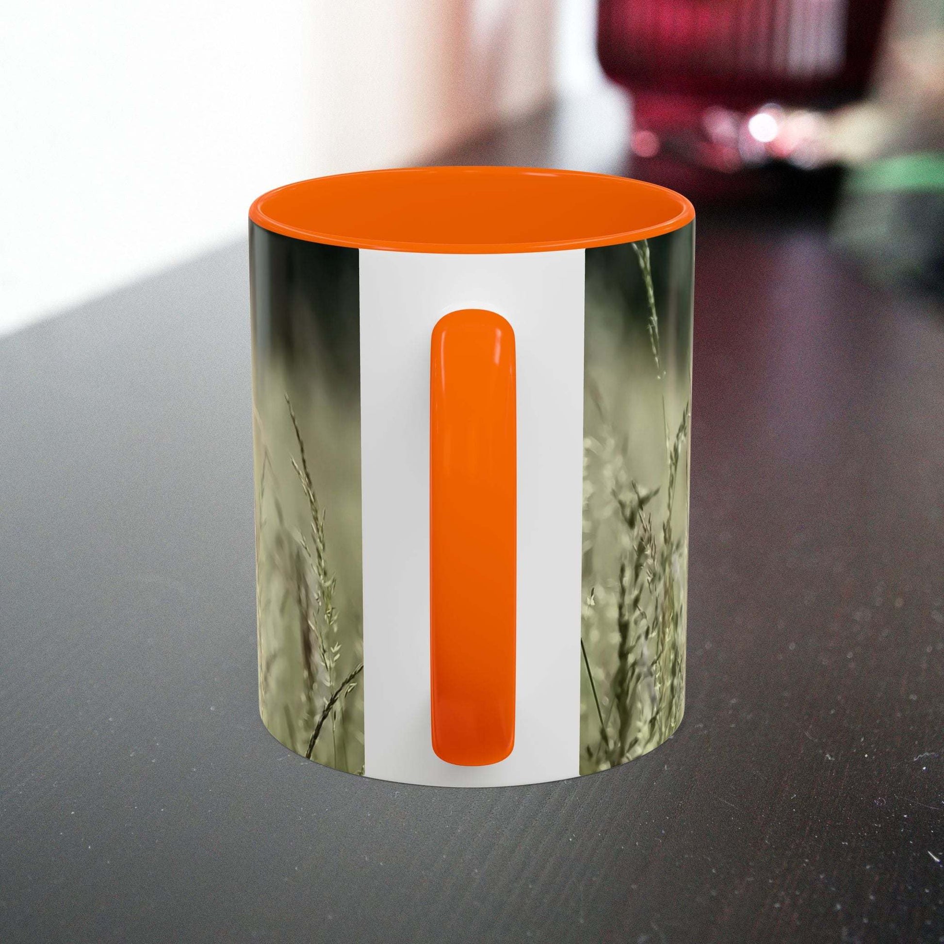 Ceramic mug with flowering grass design and orange interior, perfect for nature lovers.