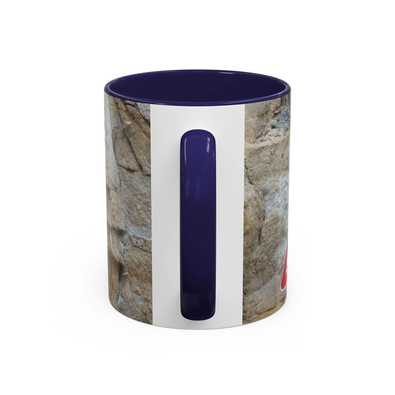 Outdoorsy 11oz Rocky Mug, Mountain Lovers, Danger of Falling Rocks by a window, displaying its navy handle and navy inside.