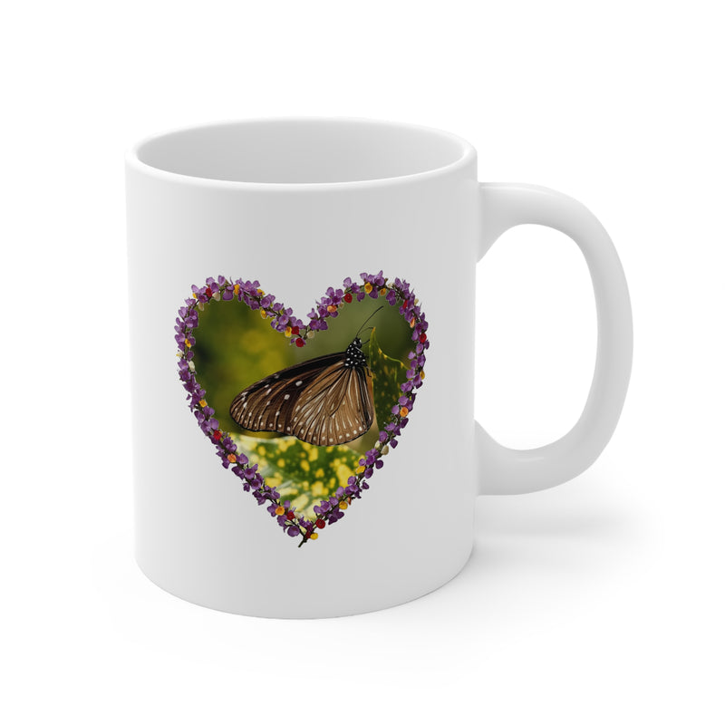 Charming 325ml ceramic coffee cup showing a resting butterfly inside a romantic purple floral heart frame artwork.