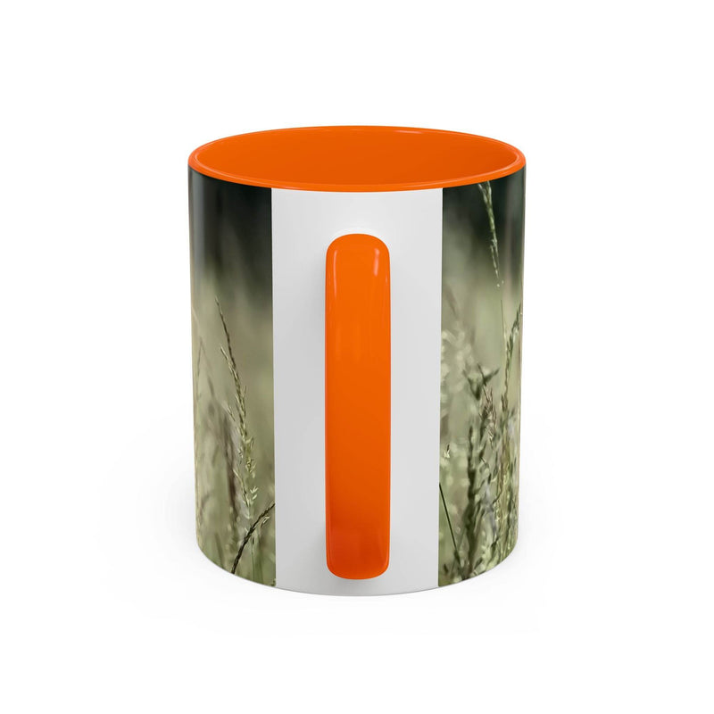 Premium 11oz Mug, Flowering Grass - Bring Nature Inside on a board, featuring an orange handle and inside.