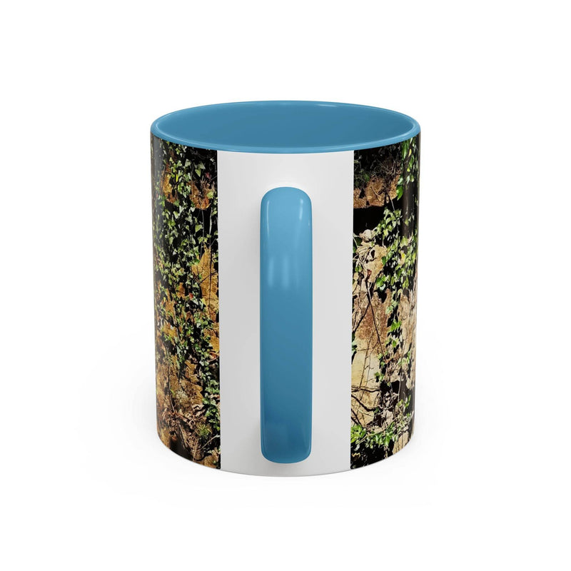 Outdoorsy 11oz Mug - Overgrown Rocks Adventure Coffee Mug on a stool, showcasing its light blue handle and inside.