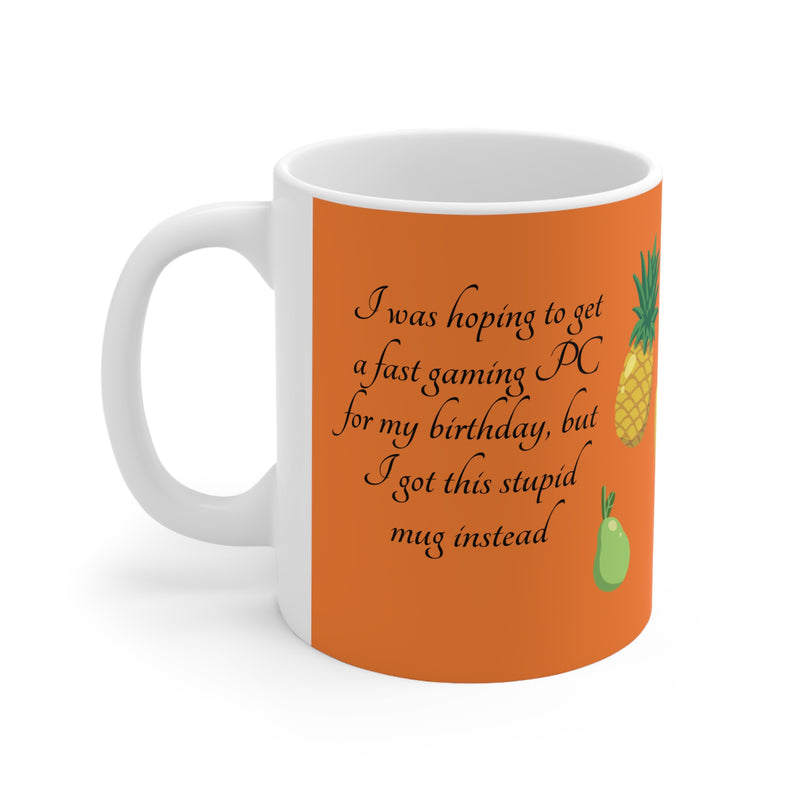 Lustiger 325ml Kaffeebecher mit dem Spruch 'I got a stupid mug for my birthday' und bunten Früchten auf orangefarbenem Hintergrund.