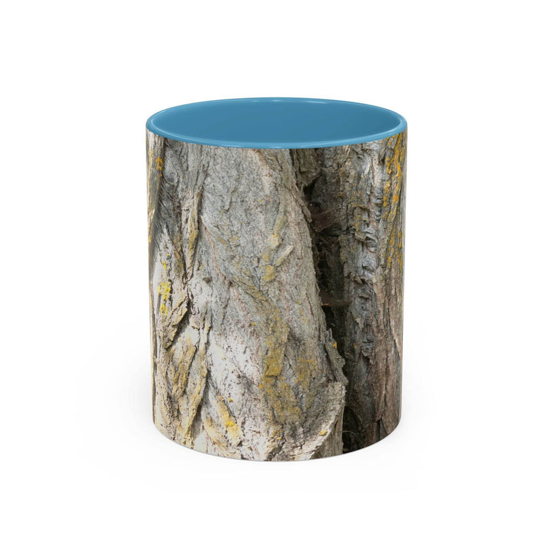 Cozy 11oz Coffee Mug - Tree Trunk Design showing the light blue handle and light blue inside beside flowers.