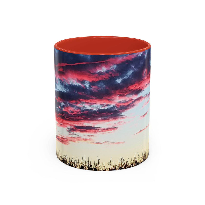 Artistic 11oz Sunset Accent Coffee Mug with a red handle and red inside on a dark wood table.