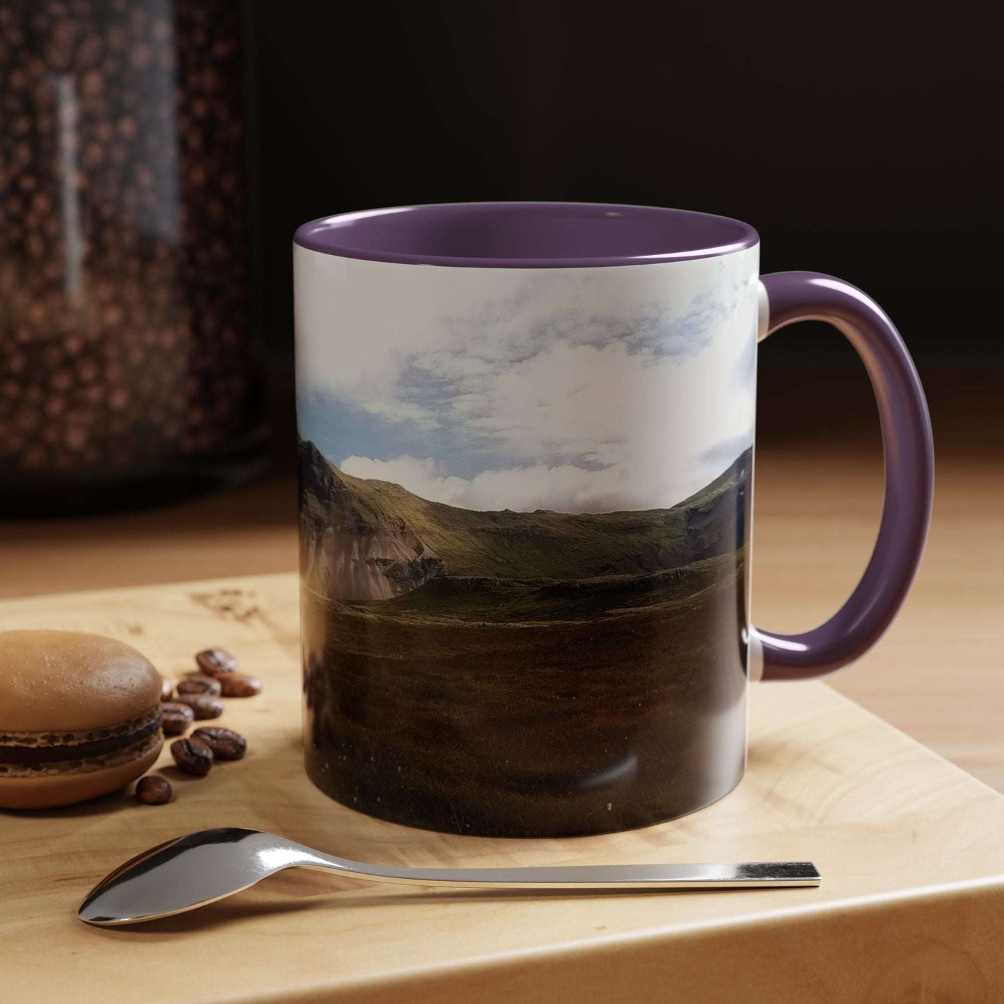 Iceland scenery coffee mug on table with spoon and macaron.