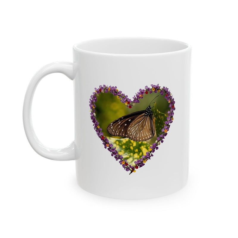 Charming 11oz ceramic coffee mug featuring a delicate heart-shaped wreath of tiny purple blooms framing a resting butterfly.