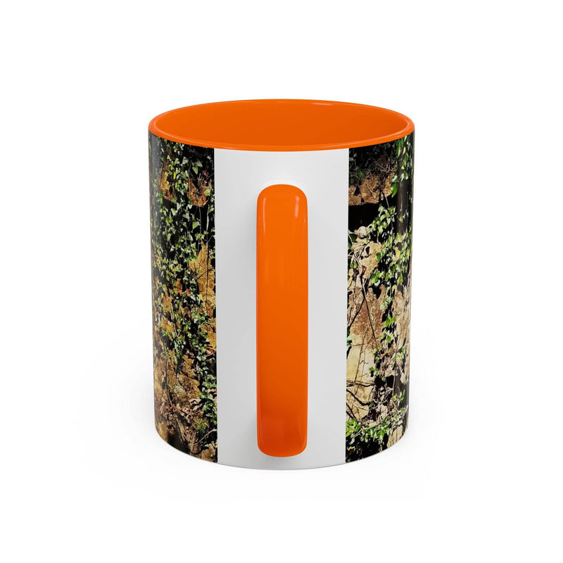 Outdoorsy 11oz Mug - Overgrown Rocks Adventure Coffee Mug on a board, showcasing its orange handle and inside.