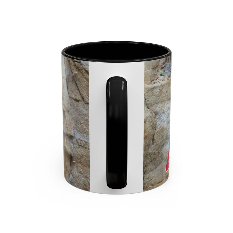 Outdoorsy 11oz Rocky Mug, Mountain Lovers, Danger of Falling Rocks held in hand, displaying black handle and black inside.