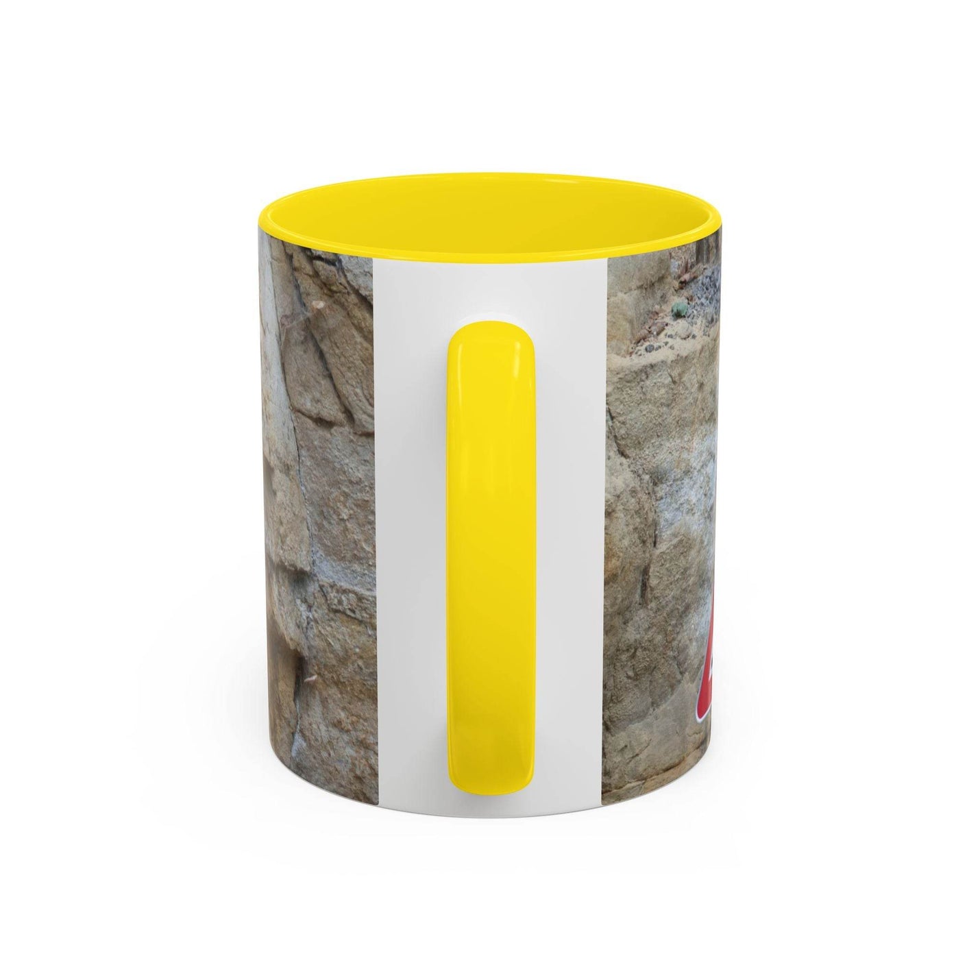 Outdoorsy 11oz Rocky Mug, Mountain Lovers, Danger of Falling Rocks on a board, showcasing its yellow handle and inside.