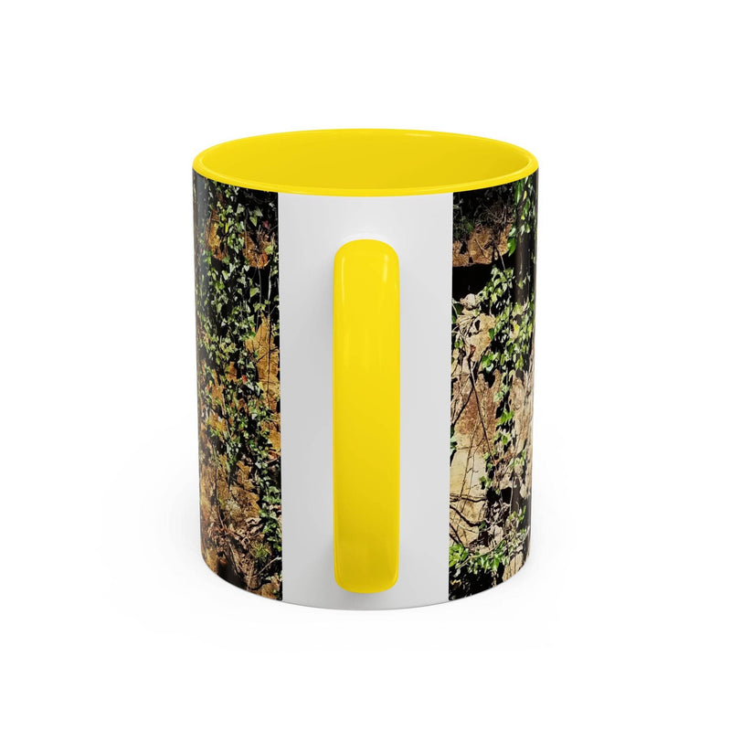 Outdoorsy 11oz Mug - Overgrown Rocks Adventure Coffee Mug on a board, showcasing its yellow handle and inside.